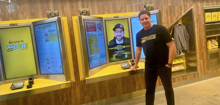Yellow Lab es un kiosco de autopedido conectado a una pantalla y cámara web que funcionan en tiempo real. Cuando el cliente se acerca hasta el TPV para hacer su pedido, la gran pantalla vertical muestra a una persona que le atiende de forma remota. Se trata de un cajero virtual.